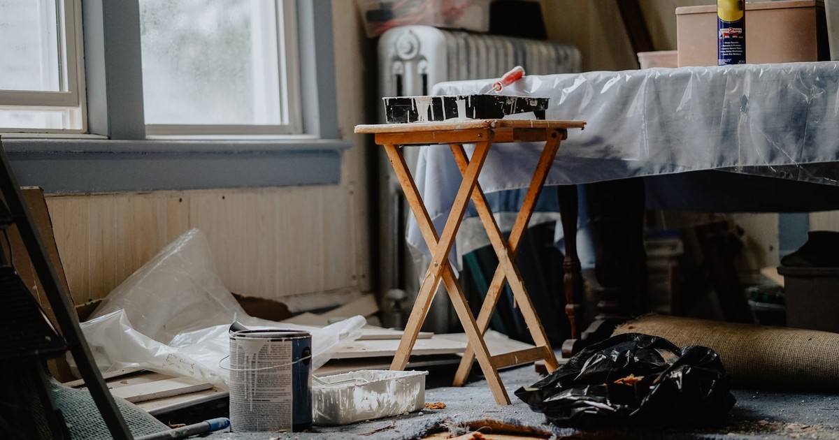 Interior view of a home renovation with paint supplies on a wooden table.