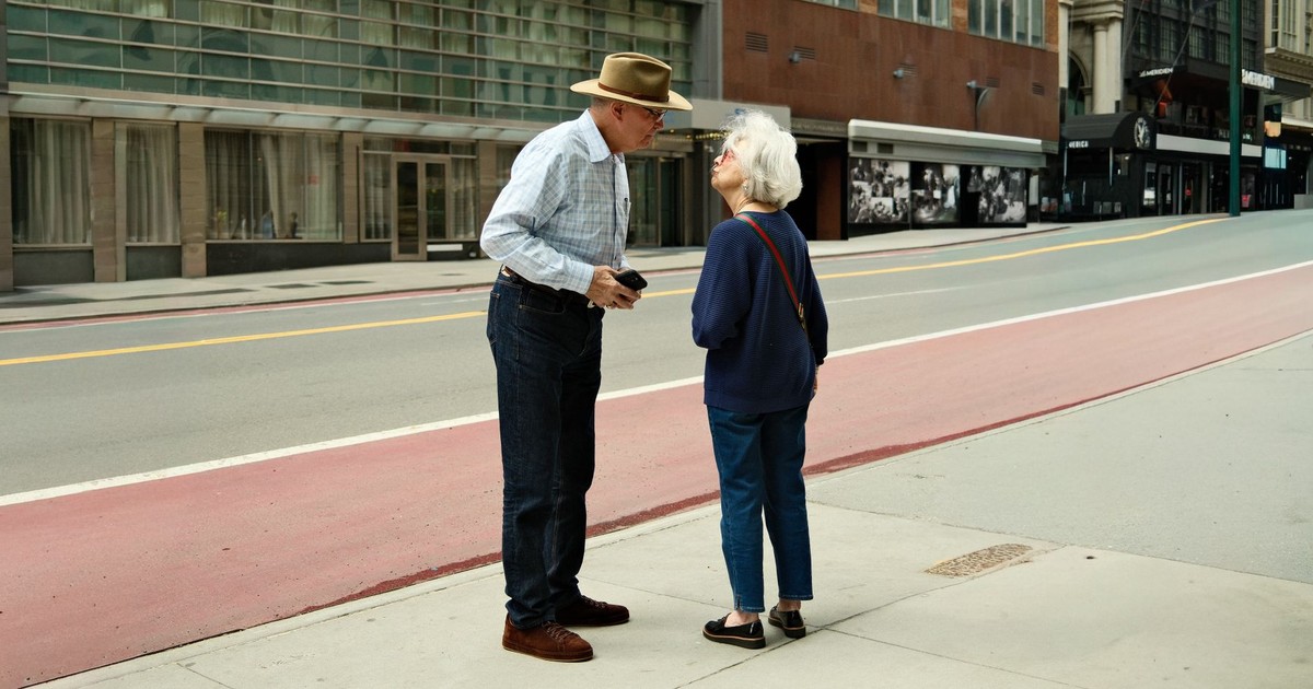 Senior couple having a conversation on a quiet city street, showcasing urban lifestyle and connection.