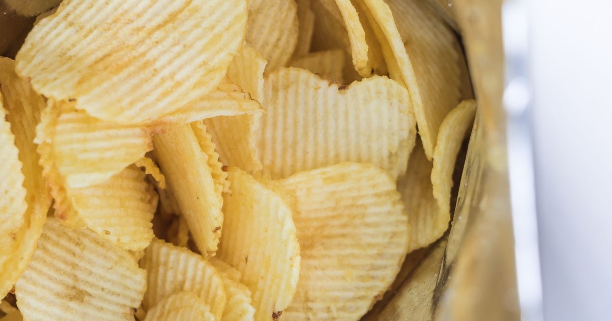 Close-up of ridged potato chips inside an opened snack bag, ready to eat.