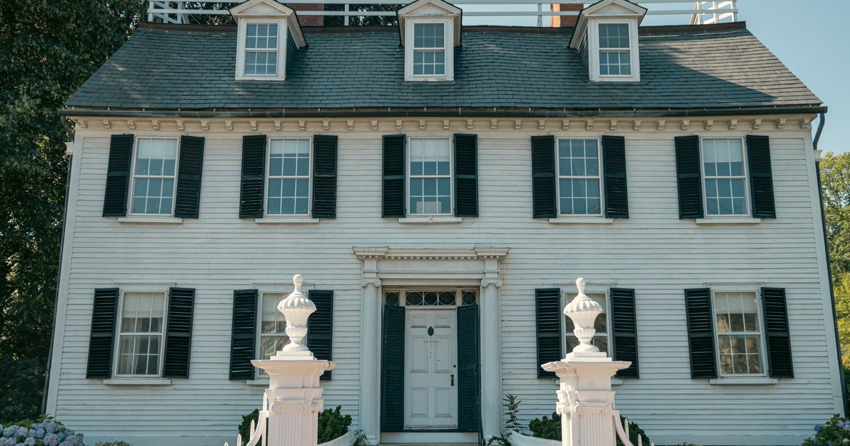 Elegant Colonial-style house with black shutters and white picket fence in Salem, Massachusetts.