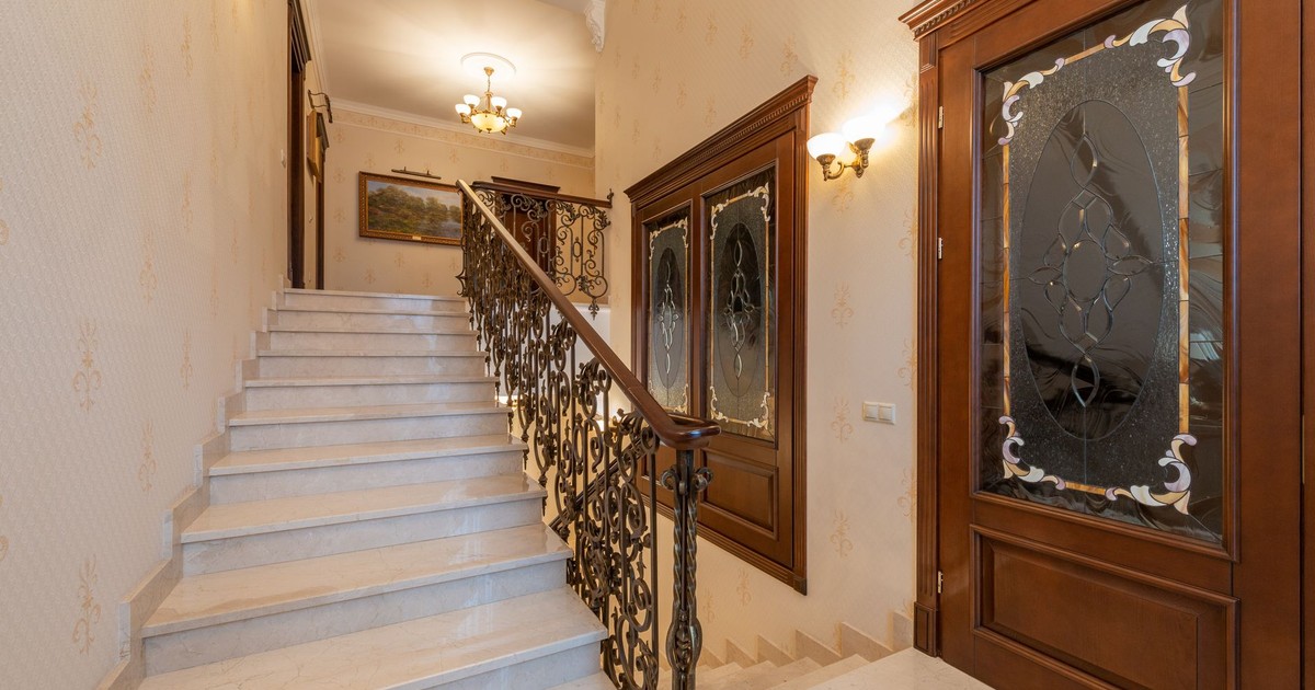 This elegant staircase features ornate railings and glass doors, creating a luxurious interior ambiance.