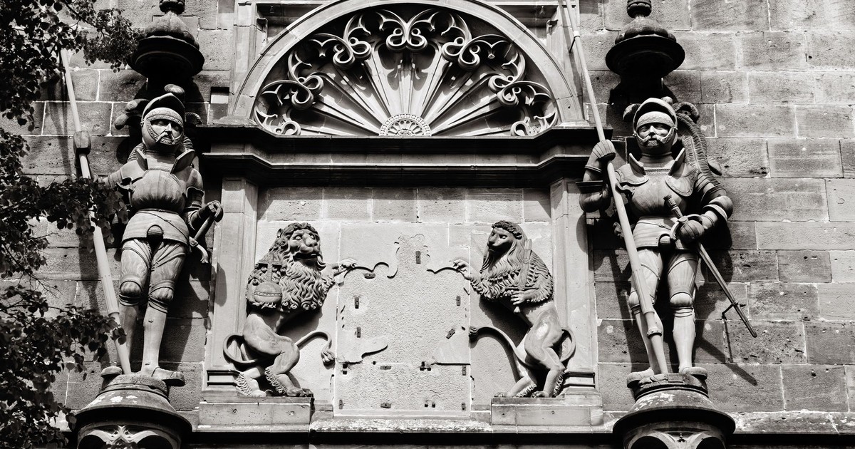 Black and white photo of sculptures on a historic building in Heidelberg, Germany.