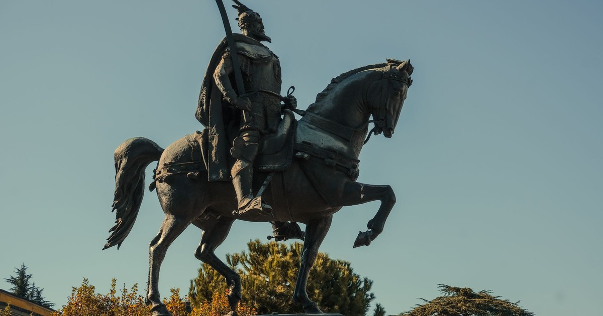 A majestic equestrian statue silhouetted against a clear blue sky, symbolizing strength.