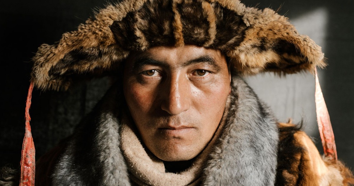 Close-up portrait of a man in traditional Mongolian fur hat and coat.