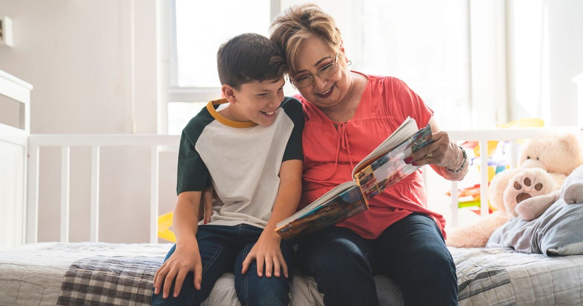 A loving grandmother and her grandson enjoy reading a book together at home.
