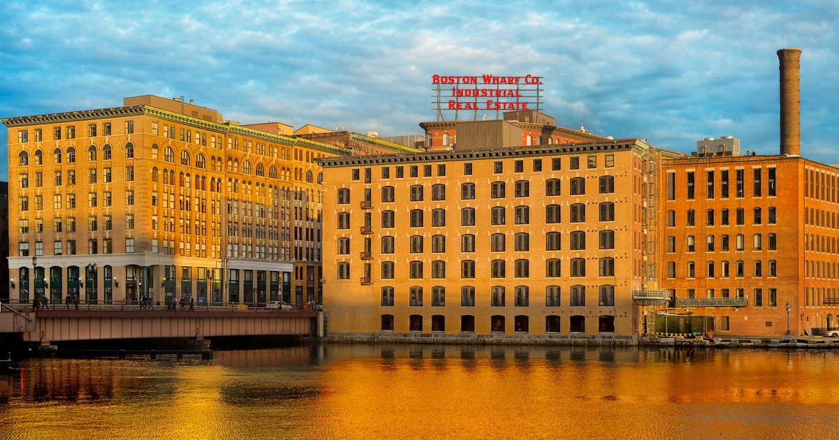 Captivating view of Boston Wharf's industrial architecture reflected in the river during daylight.