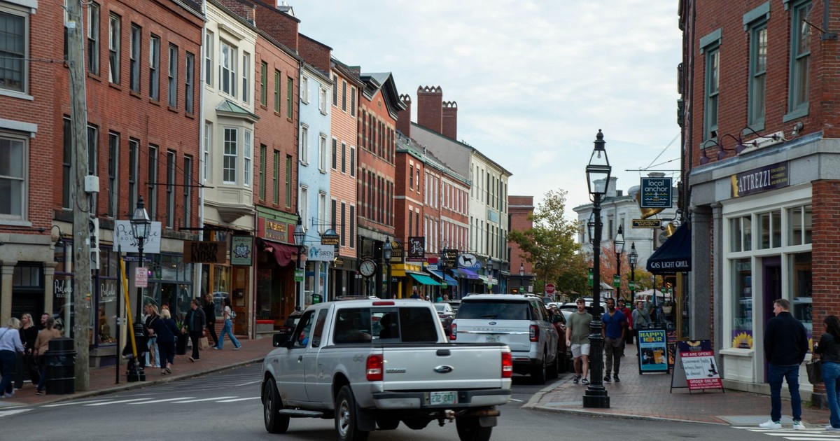 Vibrant street view of downtown Portsmouth, New Hampshire, with historic architecture and people walking.