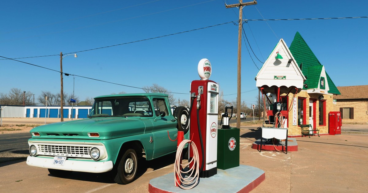 A retro gas station with a vintage truck and bright blue skies, ideal for travel nostalgia.