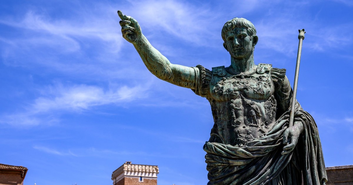 Majestic bronze statue of Julius Caesar in Rome, Italy, with historic architecture backdrop.