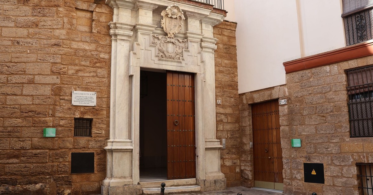 Explore the intricate stonework of a historical building entrance in Cádiz, Spain.