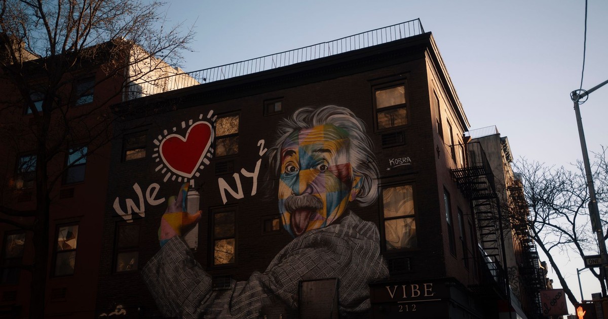 Vivid street art mural of Einstein on New York City building exterior at dusk.