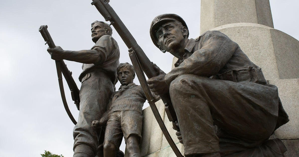 Close-up view of a war memorial with soldier sculptures in Bebington, England.