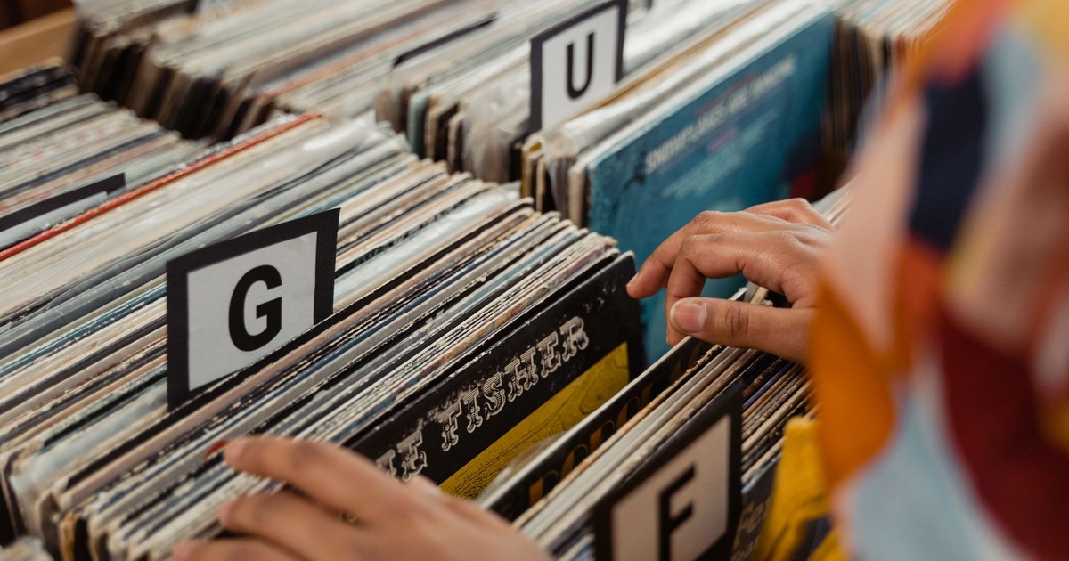 Person searching through labeled vinyl records in a store, capturing the essence of nostalgia and music.