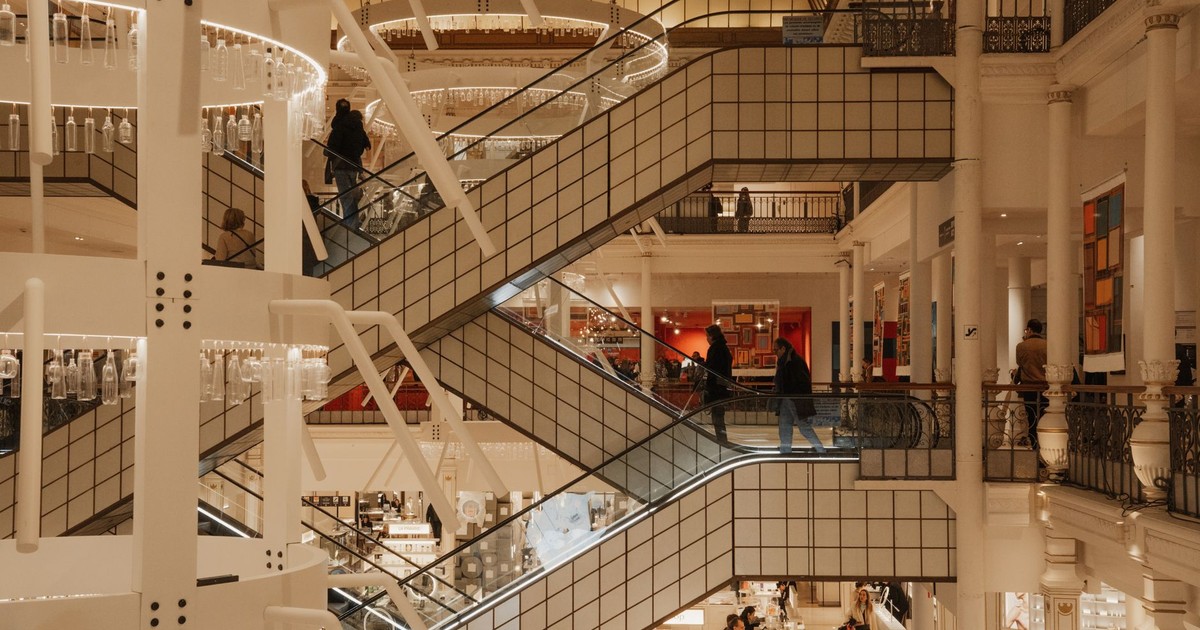 Explore the architectural beauty of a modern Parisian shopping mall with elegant escalators and geometric design.