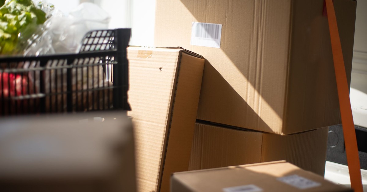 A collection of cardboard boxes inside a sunlit van, showcasing delivery logistics.