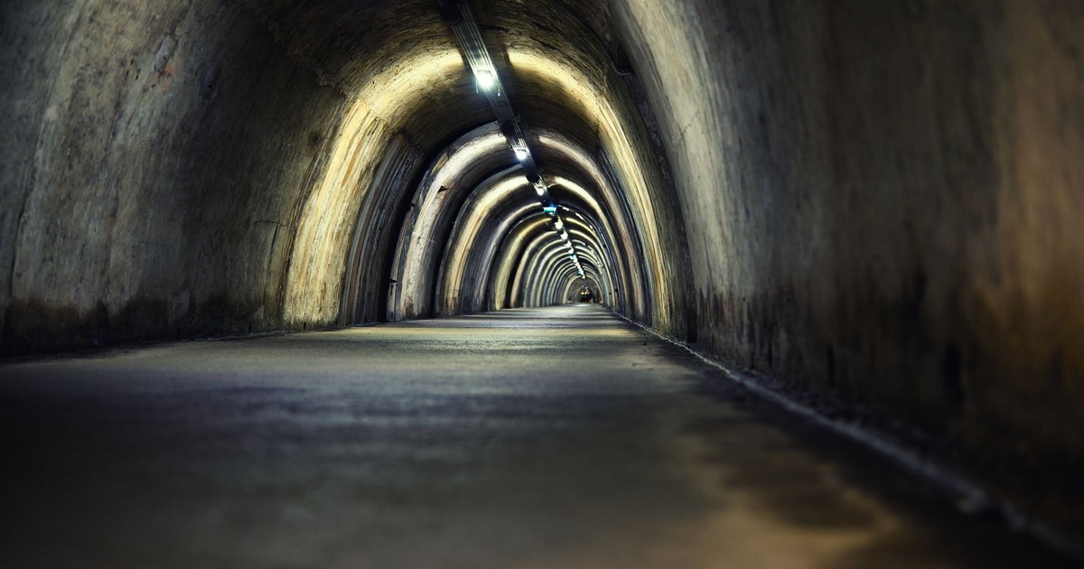 Mysterious underground tunnel with arched lights creating a moody atmosphere.