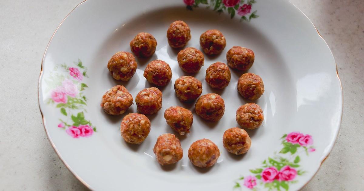 Appetizing homemade meatballs arranged on a vintage floral plate.