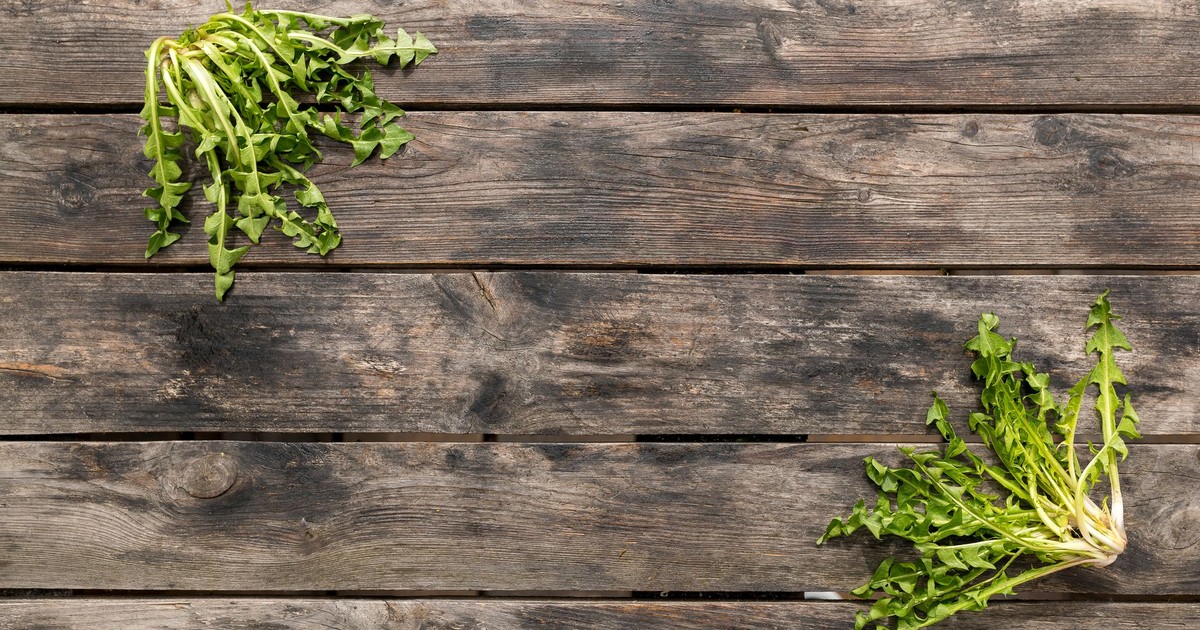 Top view of dandelion greens on a rustic wooden table, perfect for natural food presentations.