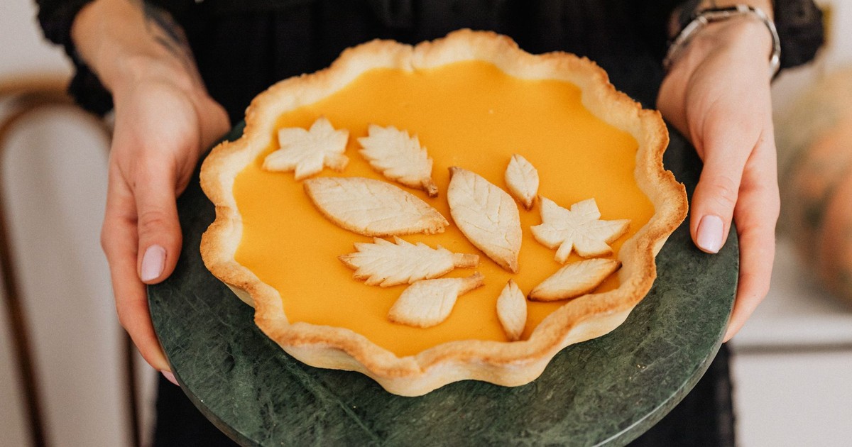 A delightful homemade pumpkin pie with decorative leaf shapes, perfect for autumn celebrations.