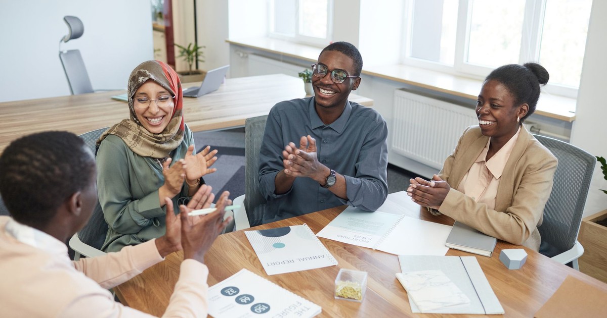 Diverse group of office workers collaborating and discussing new ideas in a bright meeting room.