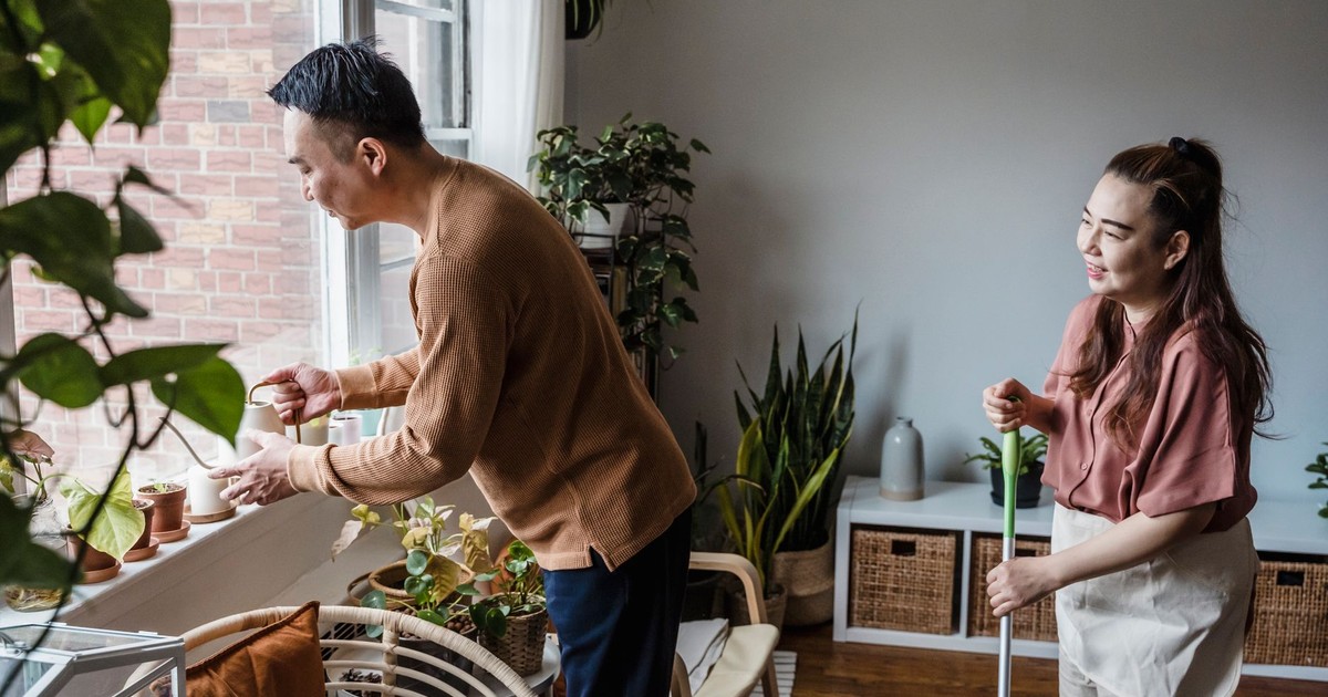 A couple tending houseplants and doing chores, showcasing harmony and togetherness.