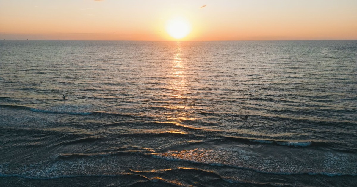 A serene ocean sunset with gentle waves and a colorful sky, perfect for tranquility and relaxation.