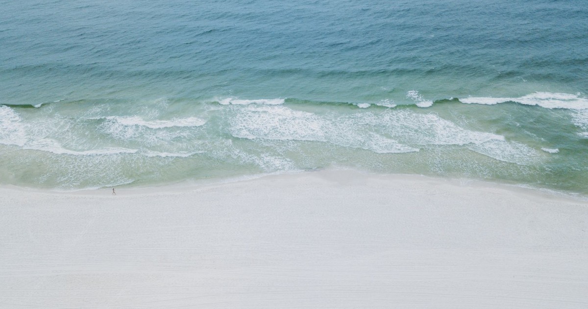 A serene aerial image showcasing the tranquil beaches and clear waters of Orange Beach, Alabama.