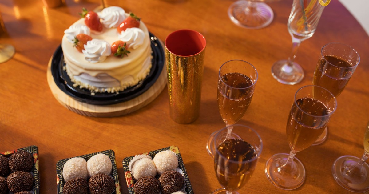 Celebrate with a delicious spread of cake, brigadeiros, and sparkling drinks on a festive table.