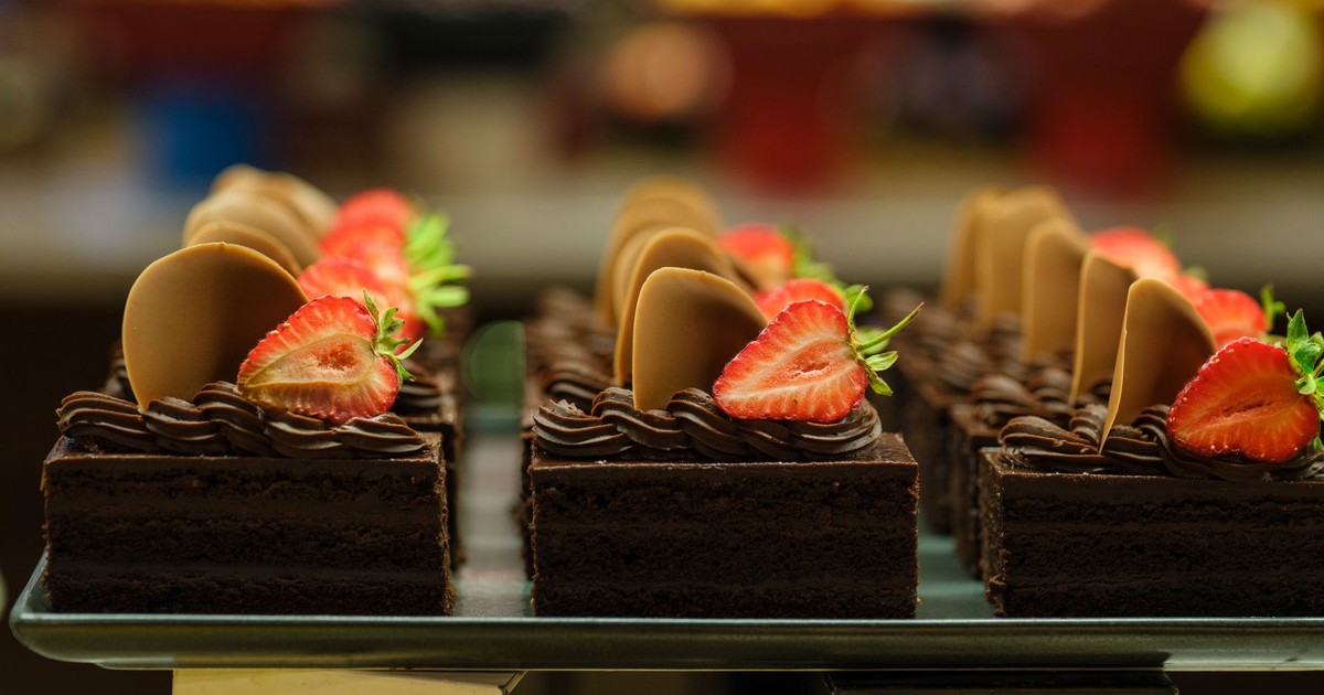 Mouth-watering chocolate cake slices adorned with fresh strawberries and chocolate rounds, perfect for dessert lovers.