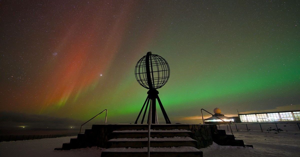 A breathtaking view of the Northern Lights over the North Cape, Norway's iconic globe monument.
