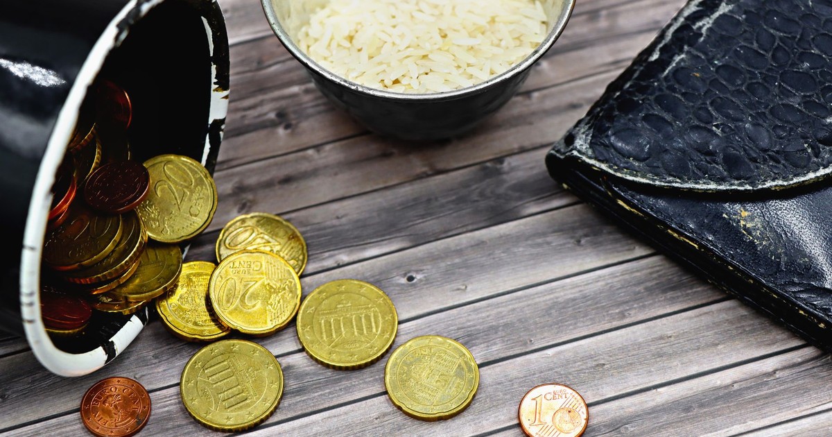 A compelling image capturing coins, a worn-out wallet, and rice, symbolizing economic hardship.