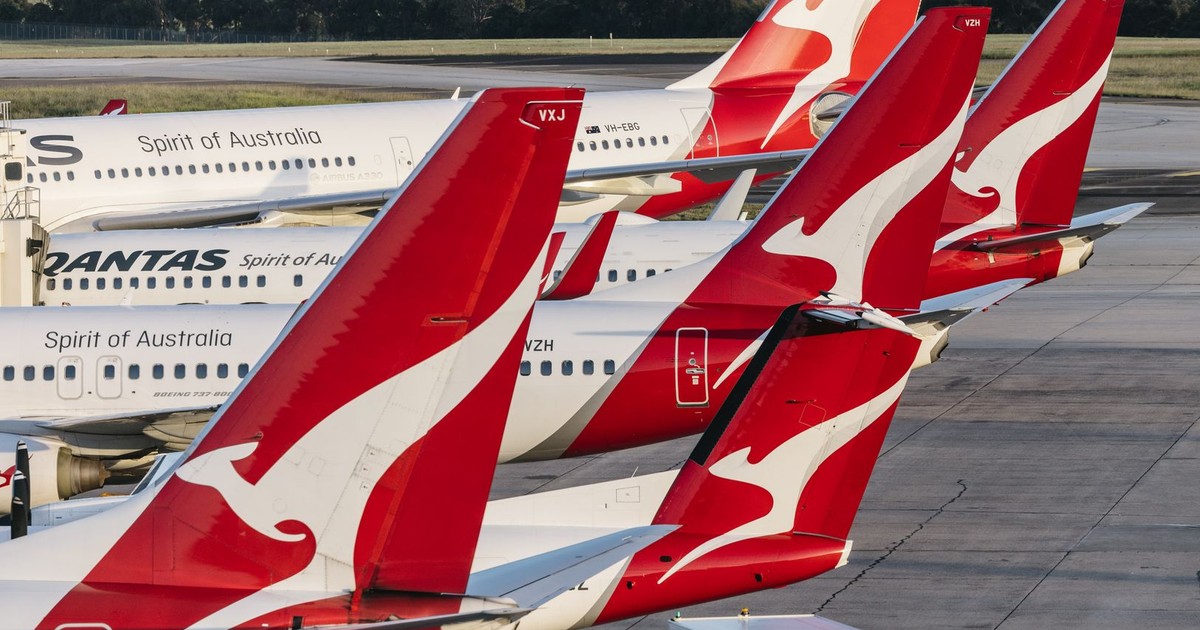 Multiple Qantas airplanes parked at Melbourne Airport, Australia, showcasing aviation and travel themes.