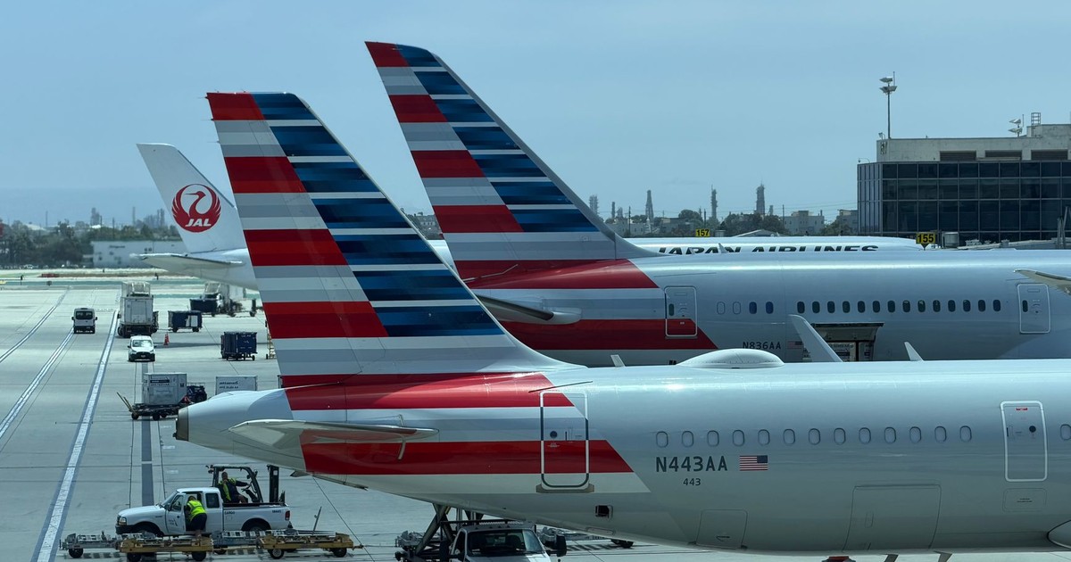 View of multiple airplane tails on the tarmac at Los Angeles International Airport on a clear day.