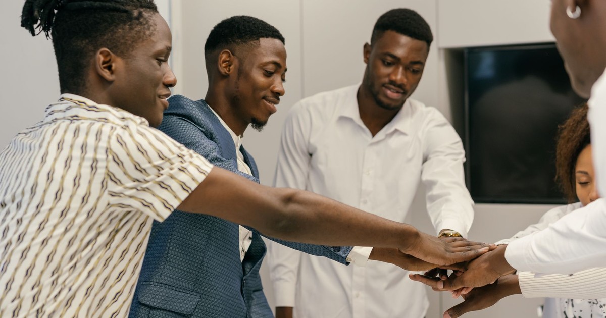 A diverse group of professionals engaging in a team-building exercise in an office environment.