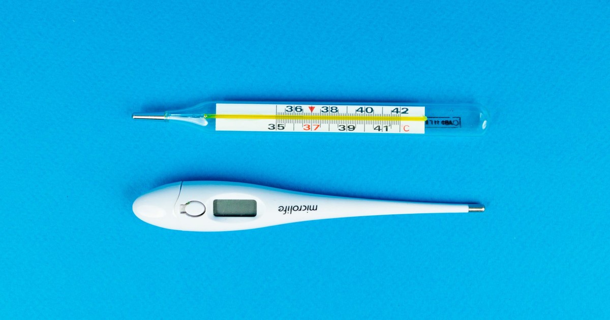 Digital and mercury thermometers on blue background for medical concept.
