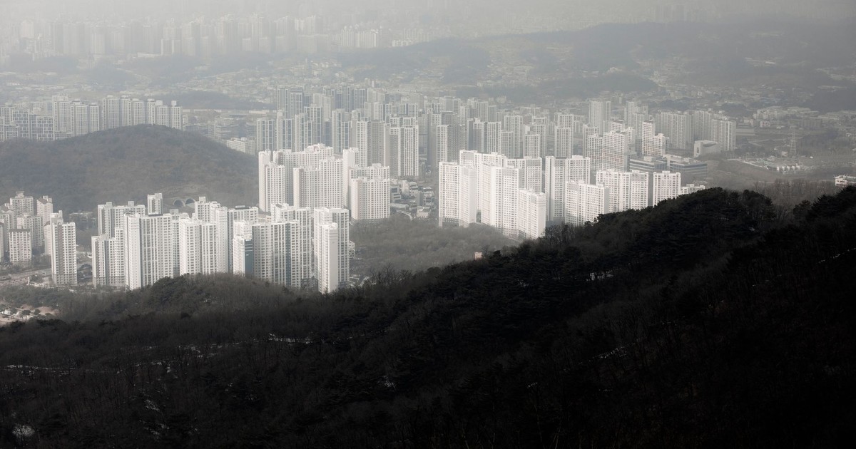 Aerial view of a sprawling cityscape featuring modern skyscrapers amidst hills.