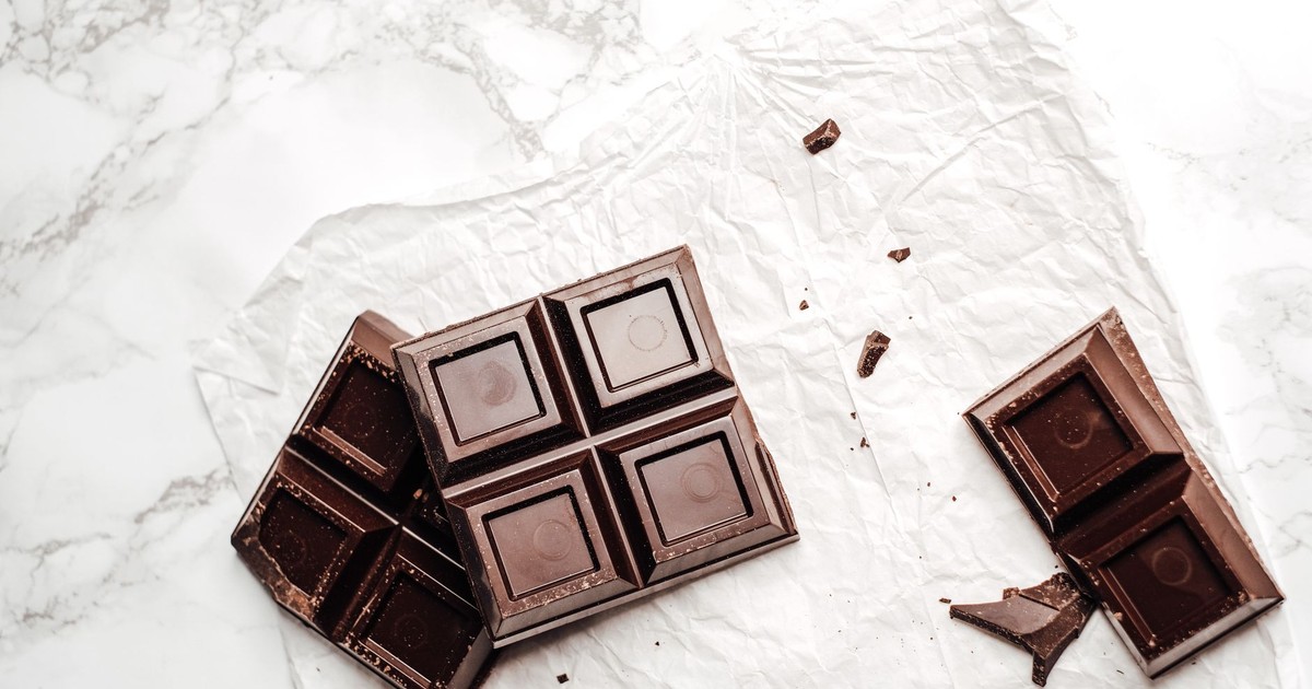 Elegant display of dark chocolate bars on a white marble surface. Perfect for dessert lovers.