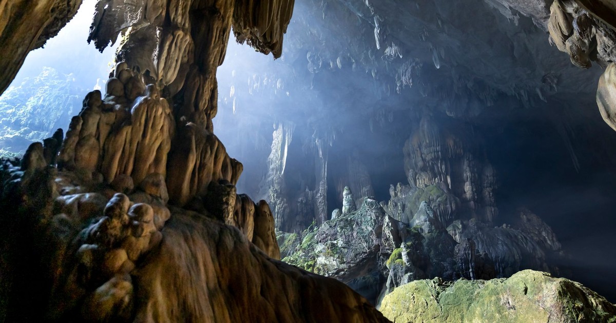 Explore the breathtaking formations of a limestone cave featuring dramatic stalagmites and sunlight peeking through.