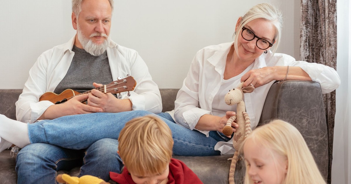 Grandparents playing with grandchildren in a cozy living room setting.