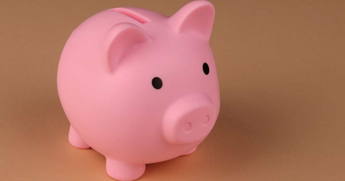 A pink piggy bank symbolizes savings and budgeting on a simple brown backdrop.