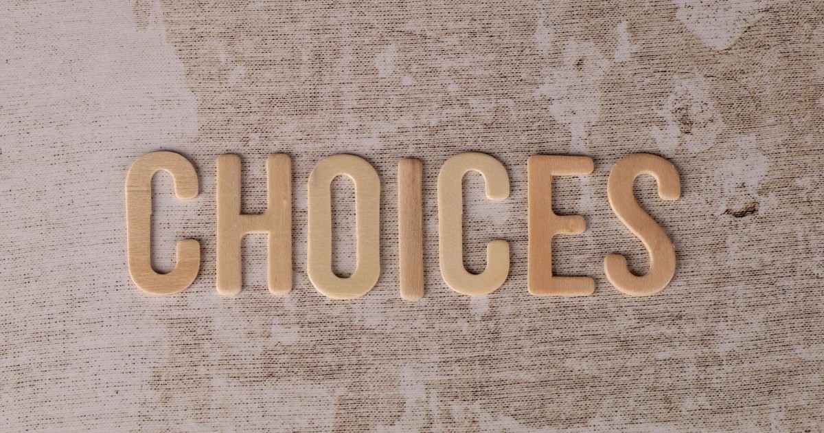 Wooden letters spelling 'choices' on a textured surface, symbolizing decision-making.