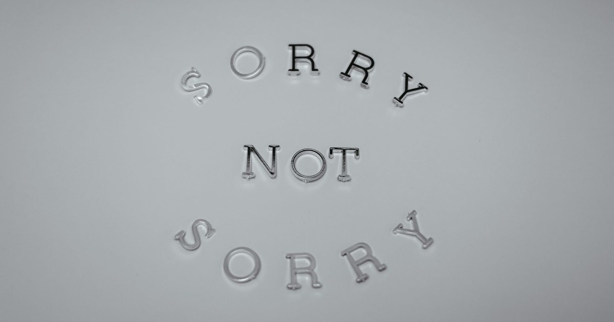 Minimalist design featuring the phrase 'Sorry Not Sorry' arranged in a circular pattern on a white background.