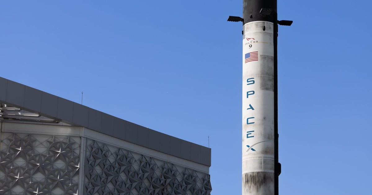 A SpaceX Falcon 9 rocket displayed outdoors against a clear blue sky in Dubai.