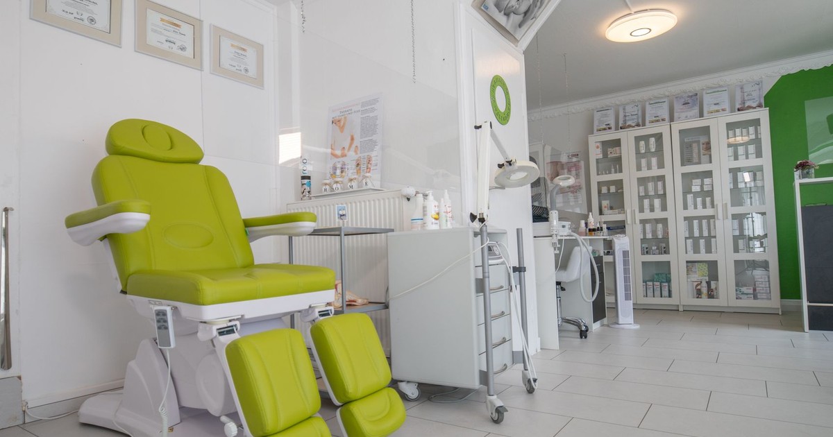 Professional equipment in doctor office with couch for medical treatment procedures behind protective screen