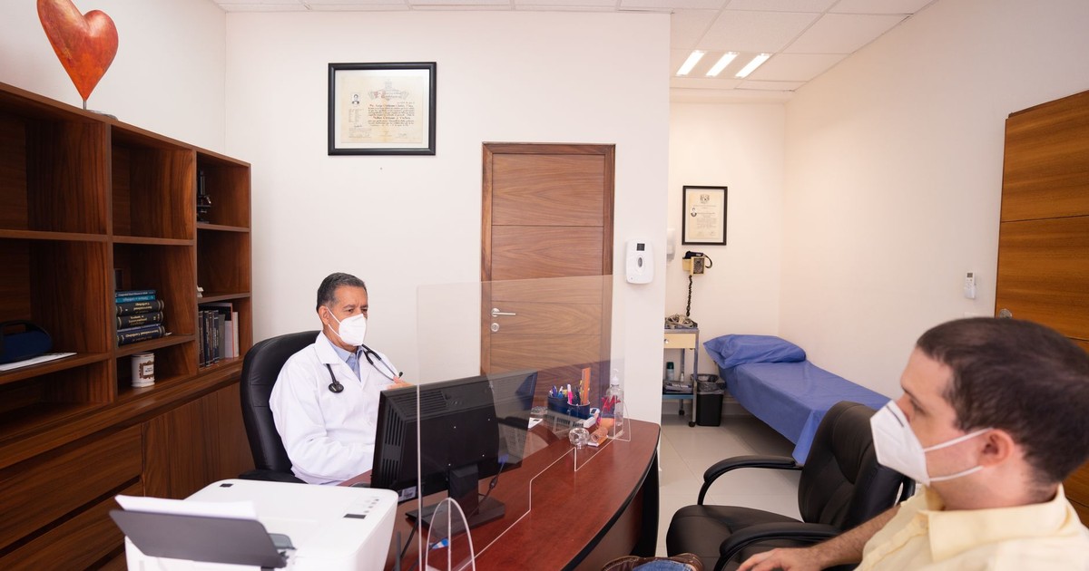 Doctor and patient with masks in medical clinic, emphasizing healthcare safety.