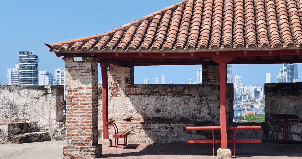 Colonial architecture meets modern skyline in Cartagena, Colombia. Captured outdoors on a sunny day.