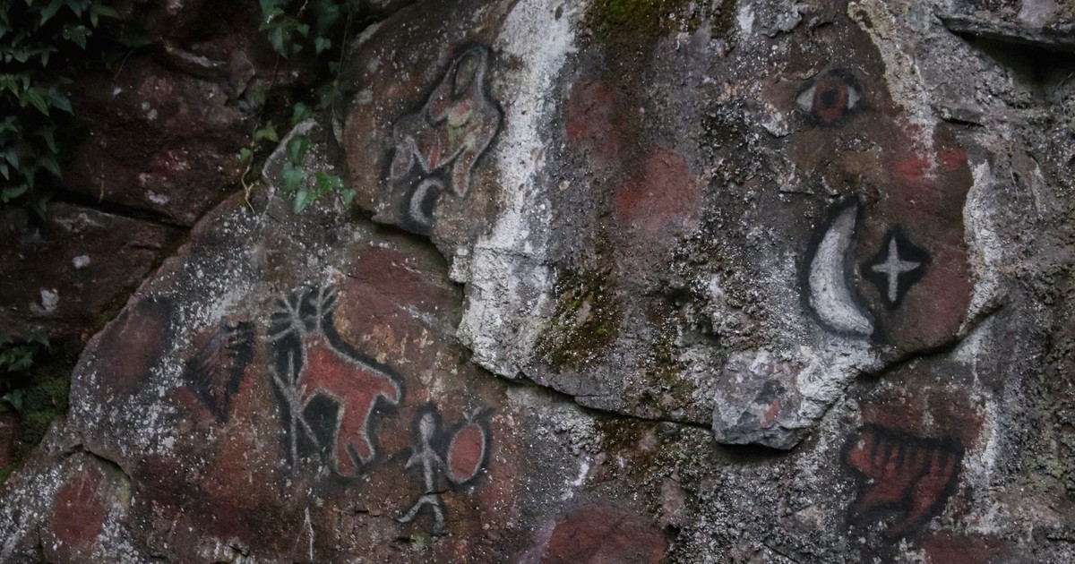 Detailed view of prehistoric art and petroglyphs on a rugged rock surface, showcasing ancient history.