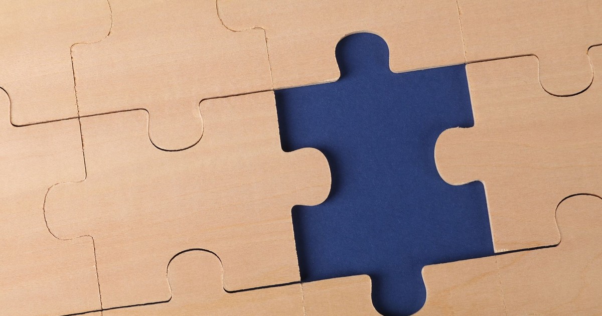 Close-up of an unfinished wooden puzzle with a missing piece, highlighting problem-solving concepts.