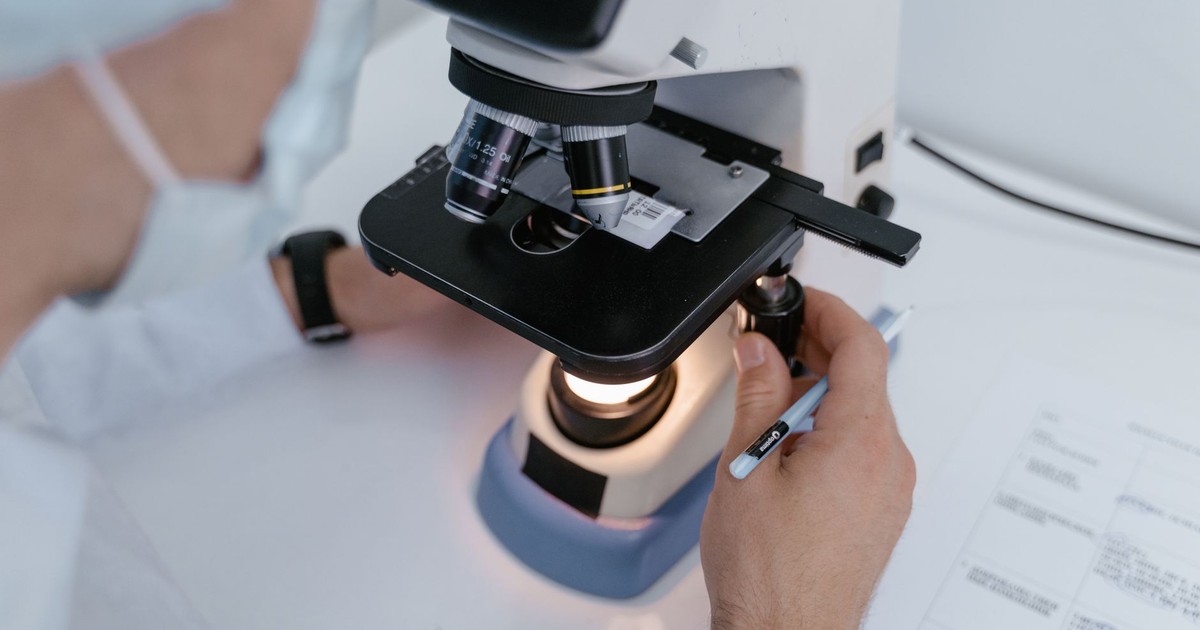 Close-up of a scientist examining samples under a microscope in a laboratory setting.