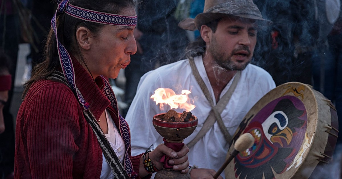 Cultural ritual with fire and music in Bogotá, Colombia, showcasing traditional attire and instruments.